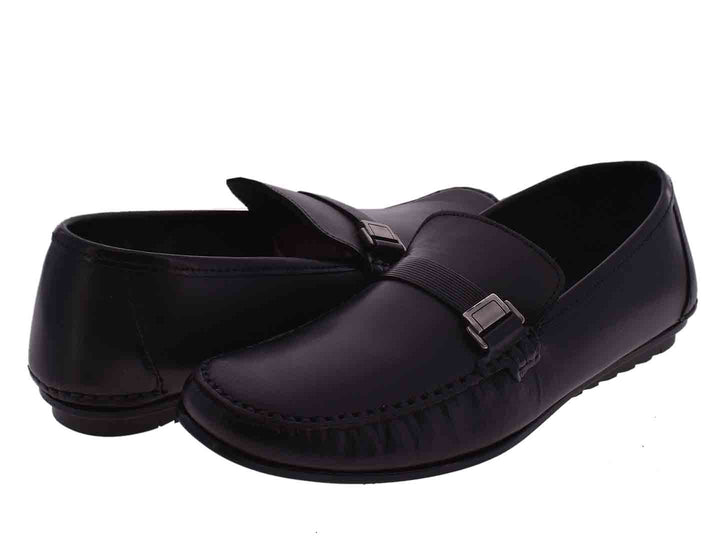 Par de mocasines negros para niño con detalle de hebilla metálica en la parte superior.