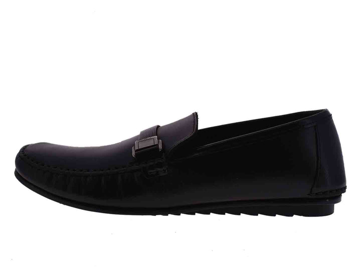 Par de mocasines negros para niño con detalle de hebilla metálica en la parte superior.