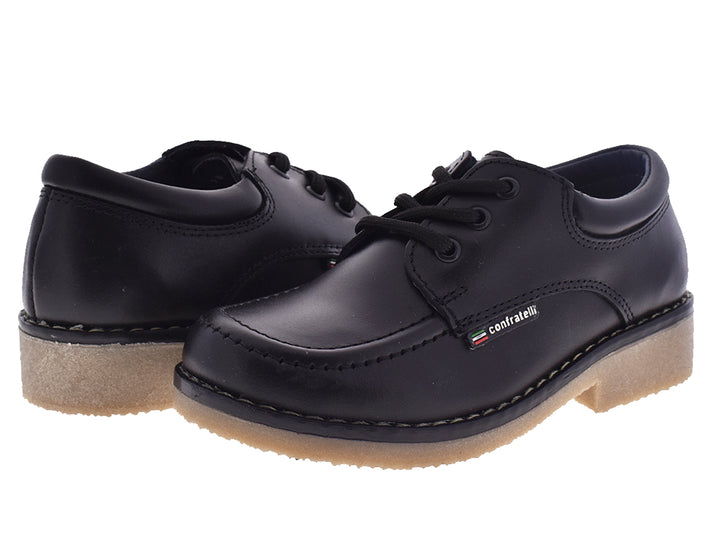 Par de zapatos negros escolares para niña con cordones y suela beige clara.