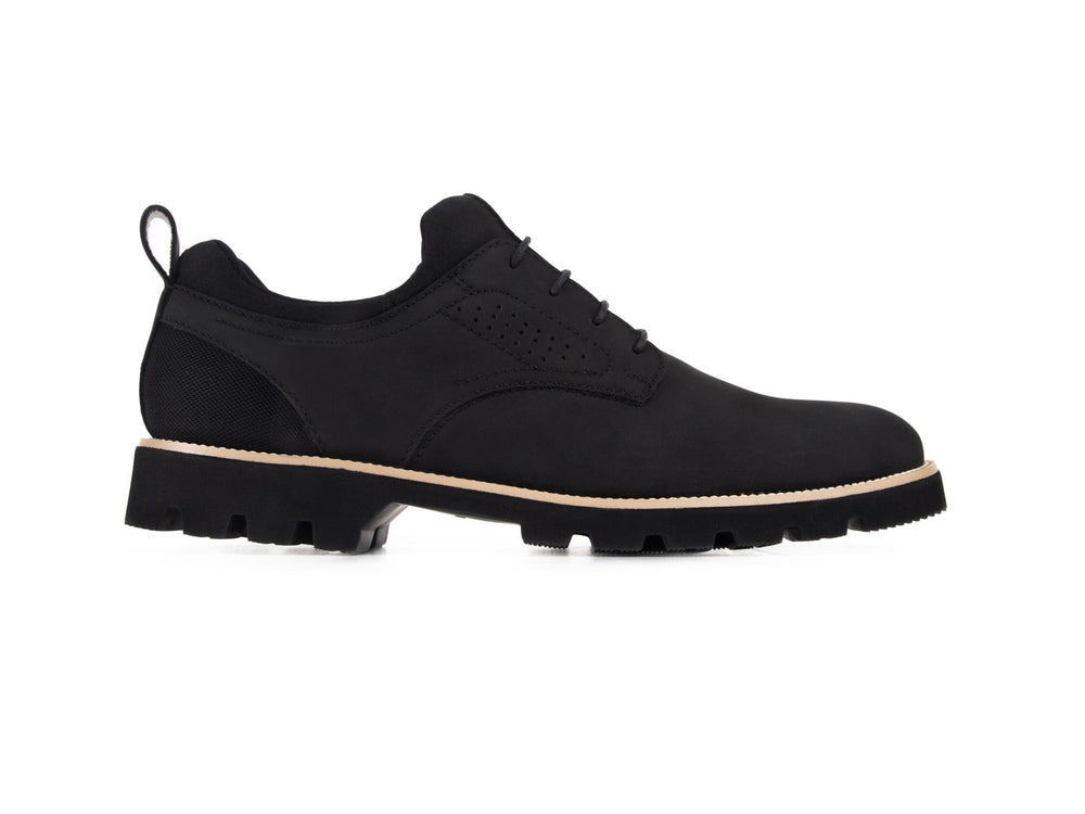Zapato casual negro para hombre con suela beige y acabado mate.