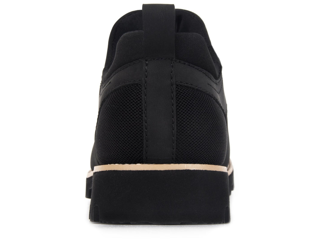 Zapato casual negro para hombre con suela beige y acabado mate.