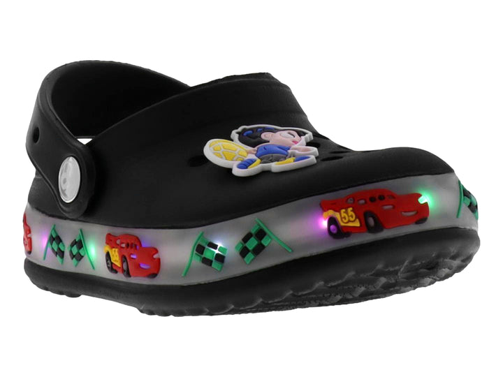 Sandalias negras tipo zueco para niño con decoraciones de carros, banderas y luces LED en la suela.