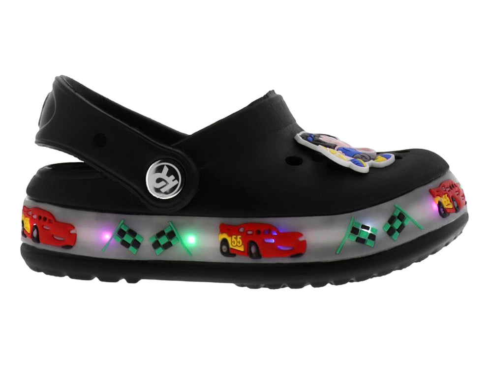 Sandalias negras tipo zueco para niño con decoraciones de carros, banderas y luces LED en la suela.