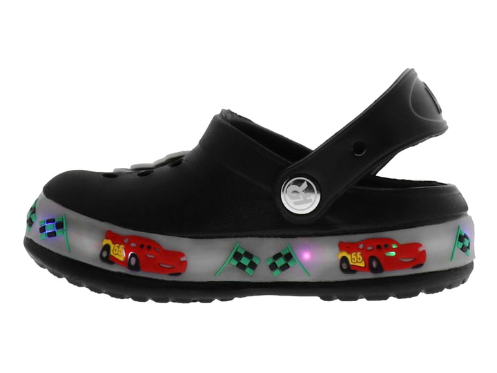 Sandalias negras tipo zueco para niño con decoraciones de carros, banderas y luces LED en la suela.