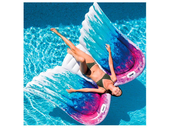 Colchón inflable con forma de alas de ángel en colores blanco, azul y morado.