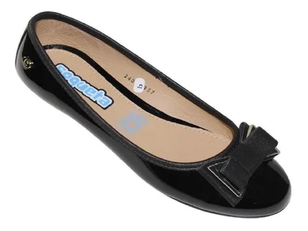 Zapato plano negro brillante para niña con detalle de moño en la parte frontal.