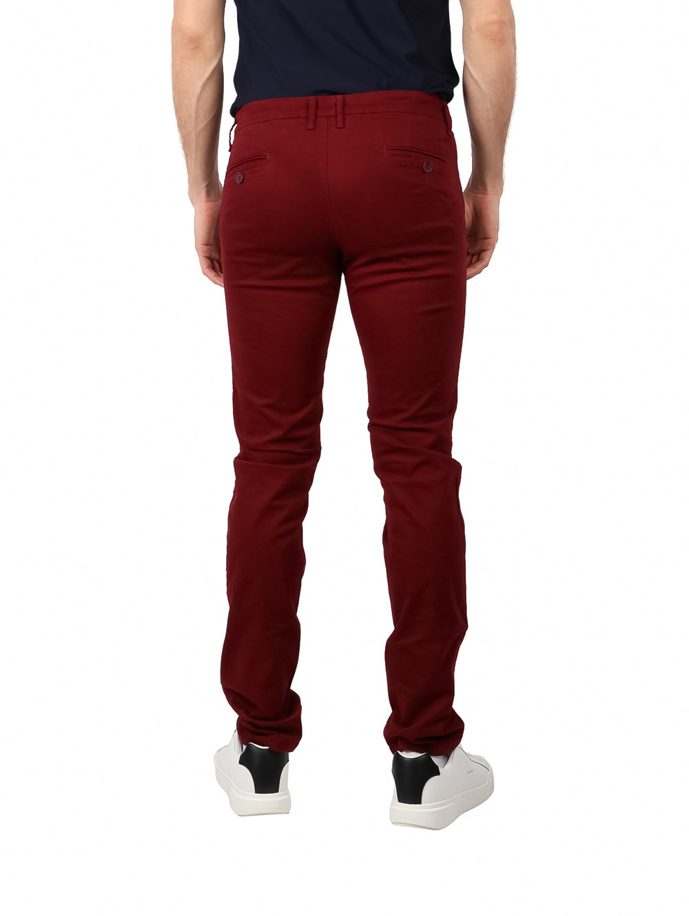 Hombre vistiendo pantalón de gabardina color vino con corte ajustado y tenis blancos.