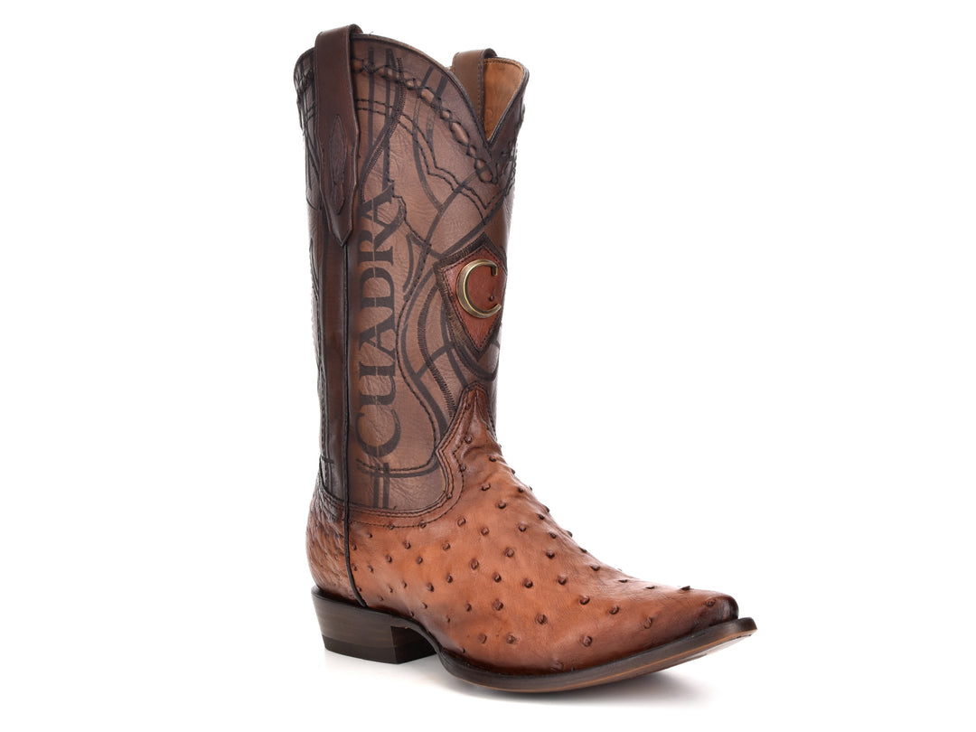Bota vaquera de cuero color castaño con detalles bordados en la caña y textura granulada en la punta.