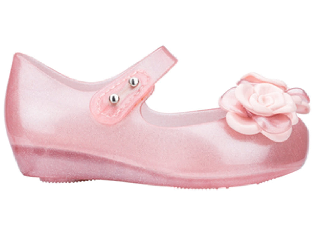 Sandalia rosa brillante de Mini Melissa para niña con adornos de flores y correa.
