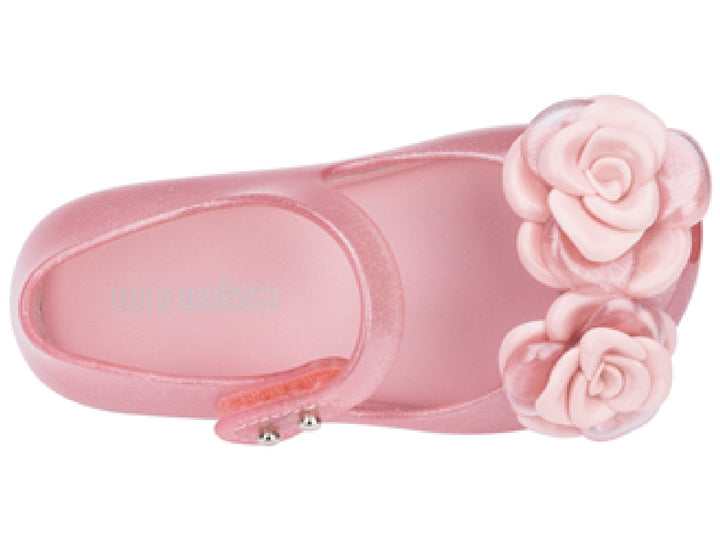 Sandalia rosa brillante de Mini Melissa para niña con adornos de flores y correa.