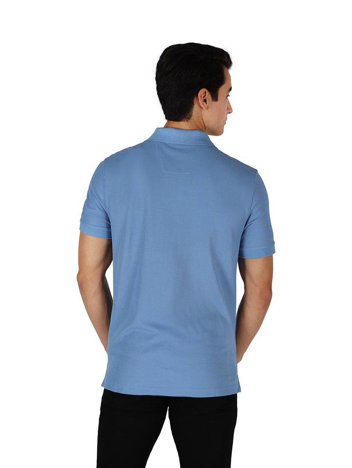 Hombre vistiendo playera polo Nautica de color azul riviera con manga corta y cuello.