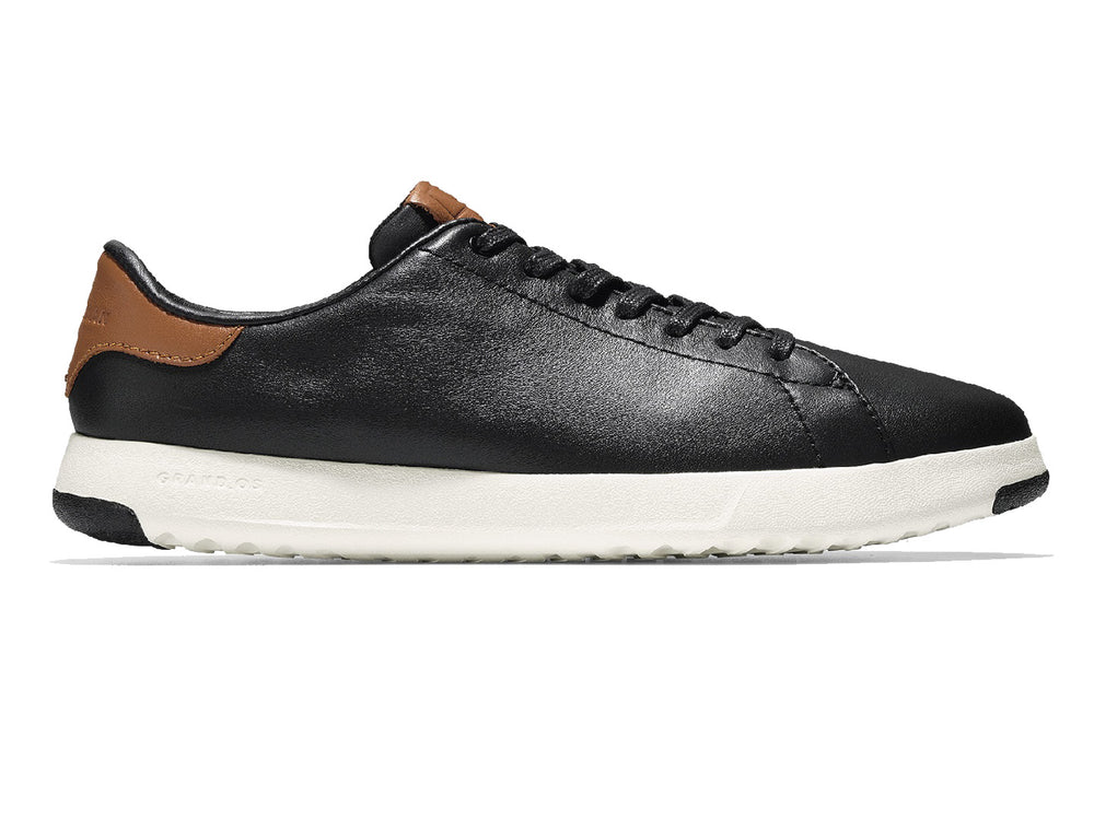 Tenis Cole Haan Grand Pro para hombre en color negro con suela blanca y detalles en color café.