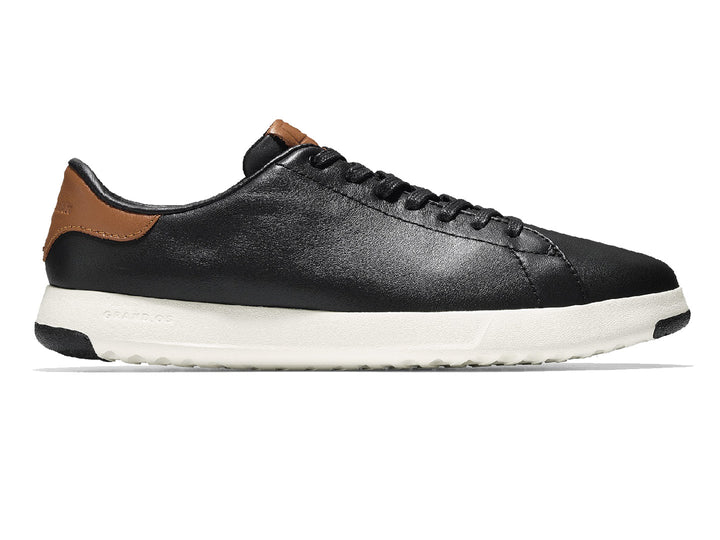Tenis Cole Haan Grand Pro para hombre en color negro con suela blanca y detalles en color café.