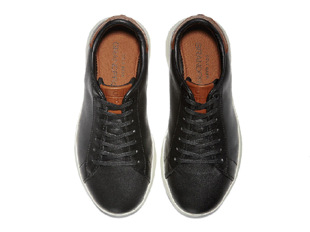 Tenis Cole Haan Grand Pro para hombre en color negro con suela blanca y detalles en color café.