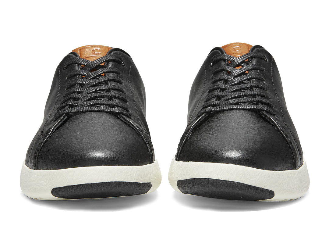Tenis Cole Haan Grand Pro para hombre en color negro con suela blanca y detalles en color café.