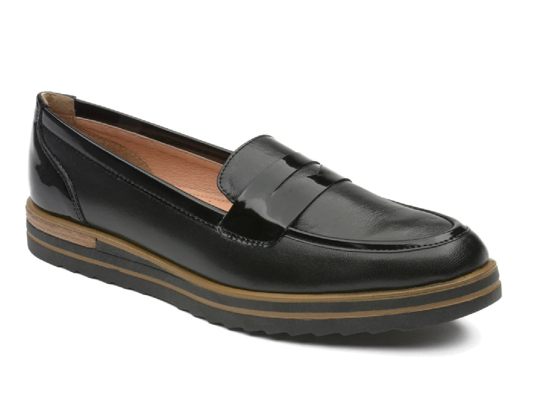 Zapato tipo mocasín de piel color negro con suela marrón.