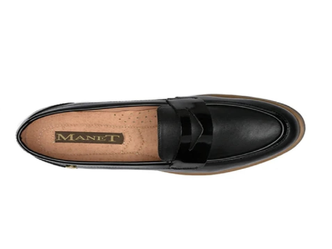 Zapato tipo mocasín de piel color negro con suela marrón.