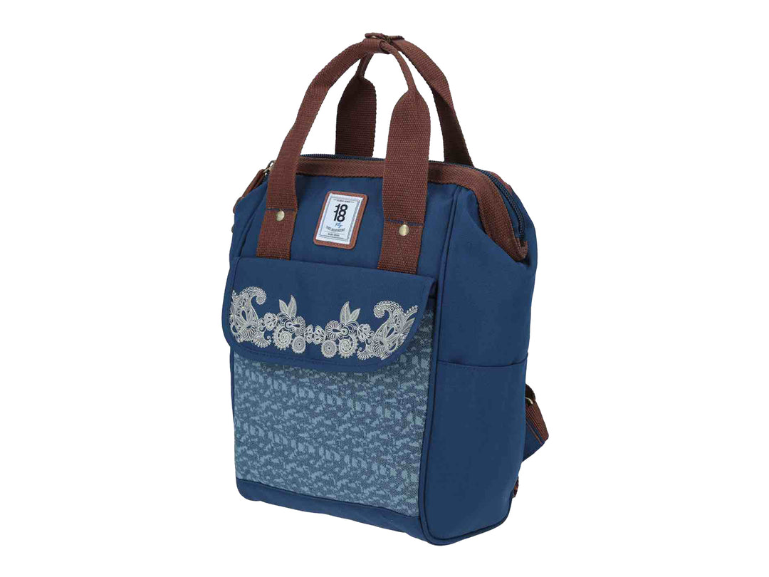 Mochila infantil azul con bordado floral blanco en el frente y asas color marrón.