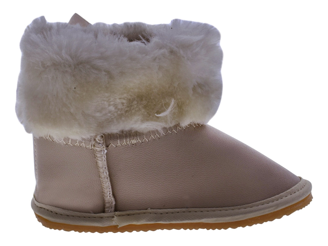 Par de botas color oro para bebé con detalles de moño y borde de peluche blanco.