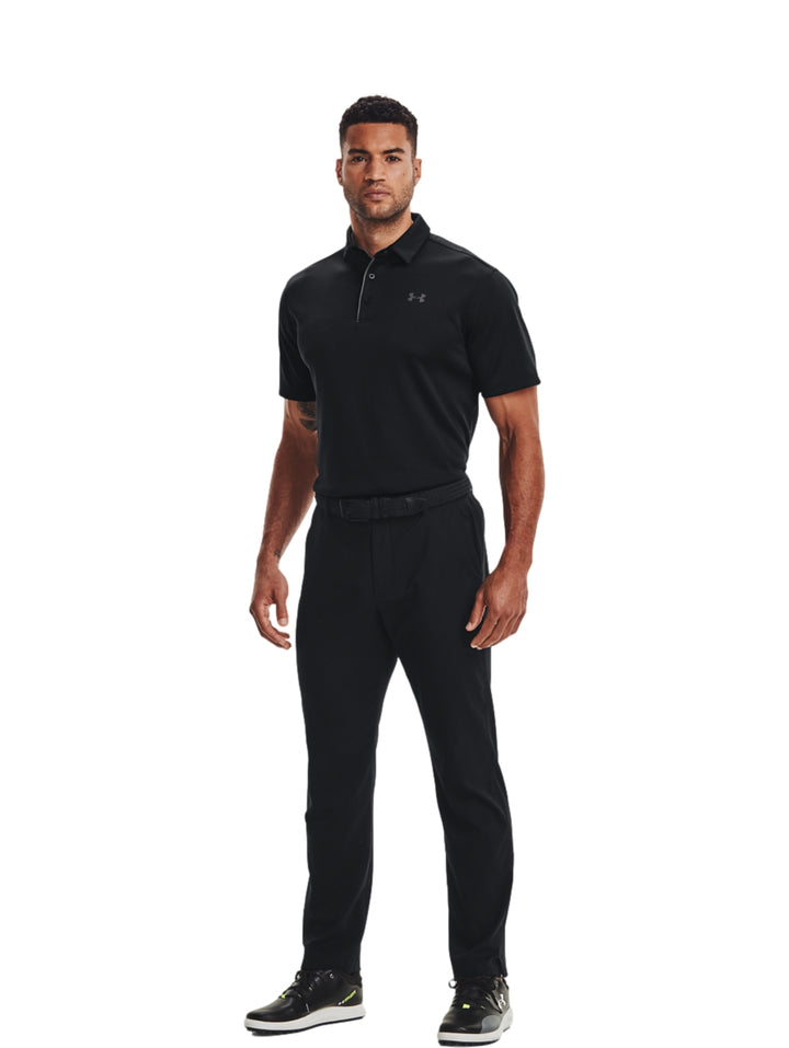 Hombre vistiendo playera polo deportiva Under Armour de color negro con detalles en gris.