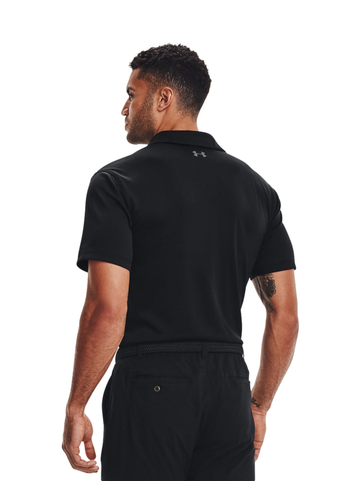 Hombre vistiendo playera polo deportiva Under Armour de color negro con detalles en gris.