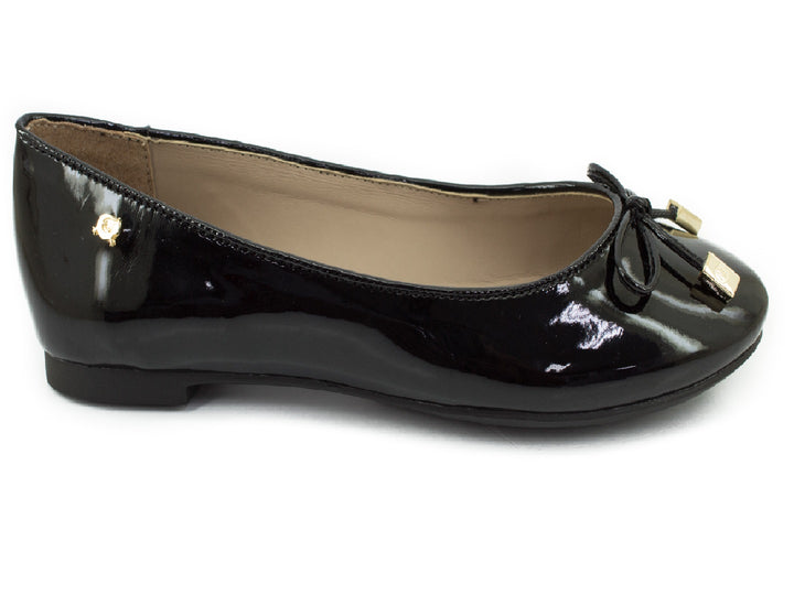 Zapato plano de mujer en charol negro con un moño y detalles decorativos en color dorado.
