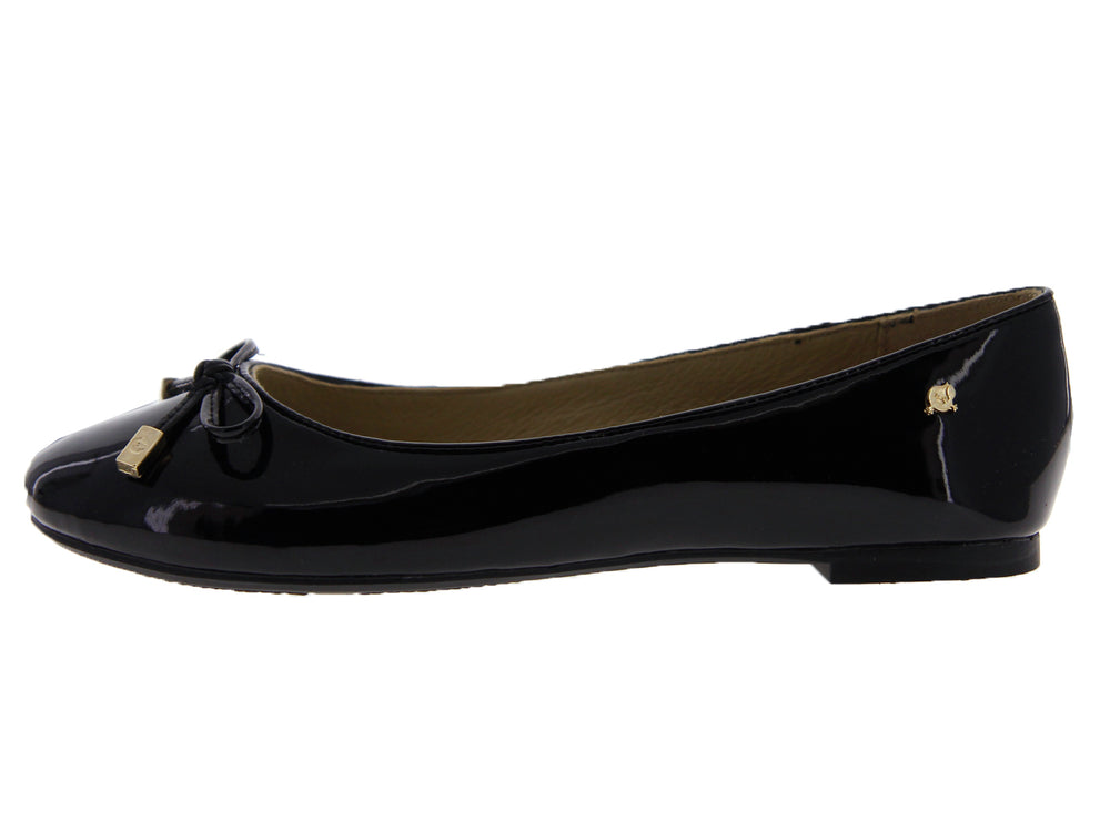 Zapato plano de mujer en charol negro con un moño y detalles decorativos en color dorado.