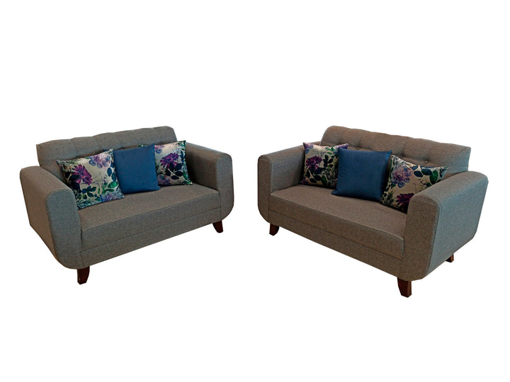Juego de sala de dos piezas color gris con cojines decorativos azules y florales.