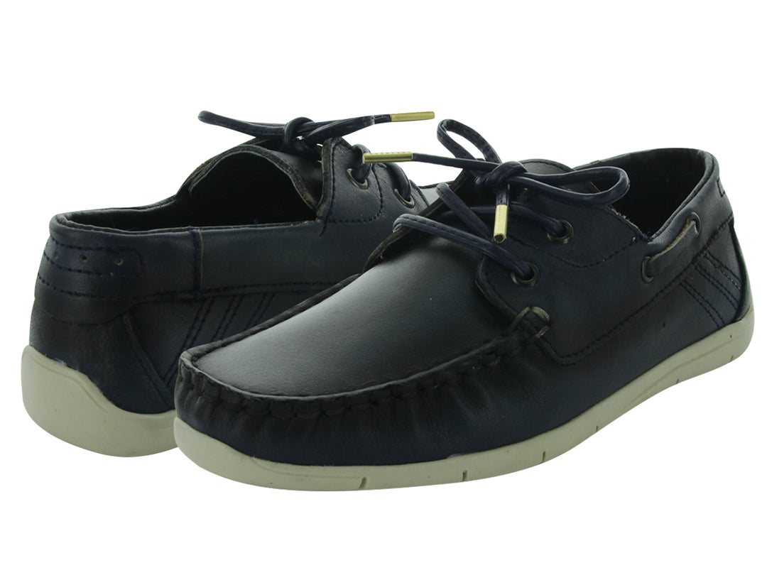 Zapatos casuales tipo náutico para niño en color azul marino con suela blanca y cordones.