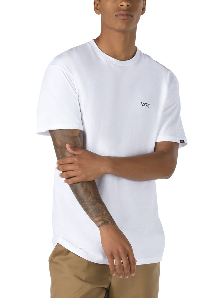 Hombre vistiendo una camiseta blanca de manga corta con logotipo pequeño de Vans en el pecho izquierdo.