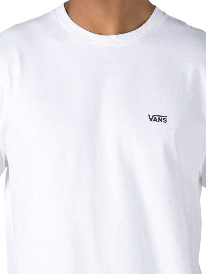 Hombre vistiendo una camiseta blanca de manga corta con logotipo pequeño de Vans en el pecho izquierdo.