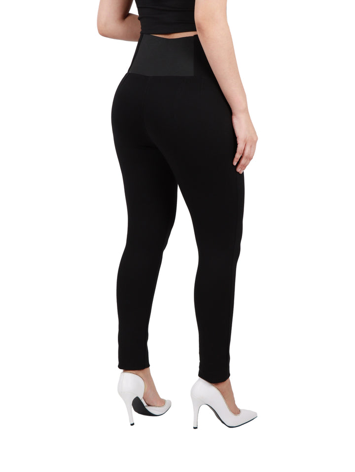 Mujer vistiendo leggings negros de tiro alto con cremallera frontal.