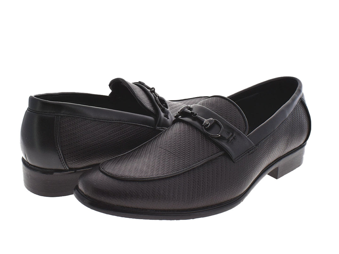 Par de zapatos mocasines color negro con textura y detalle de hebilla metálica.