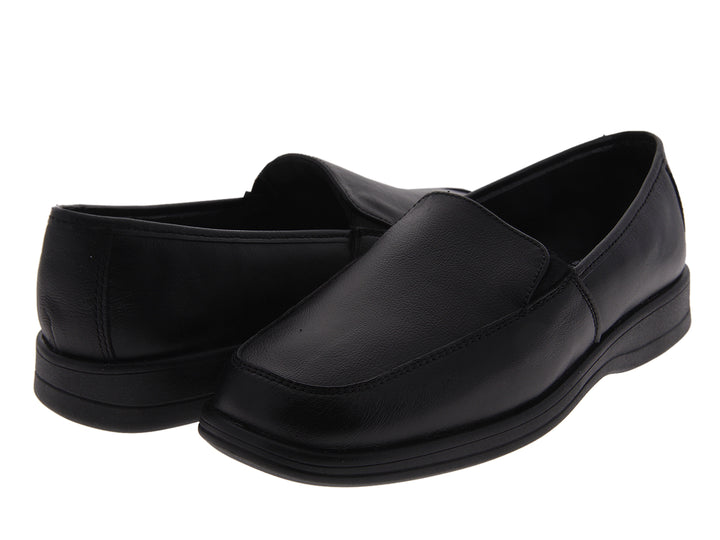 Par de zapatos planos de cuero color negro, estilo slip-on.