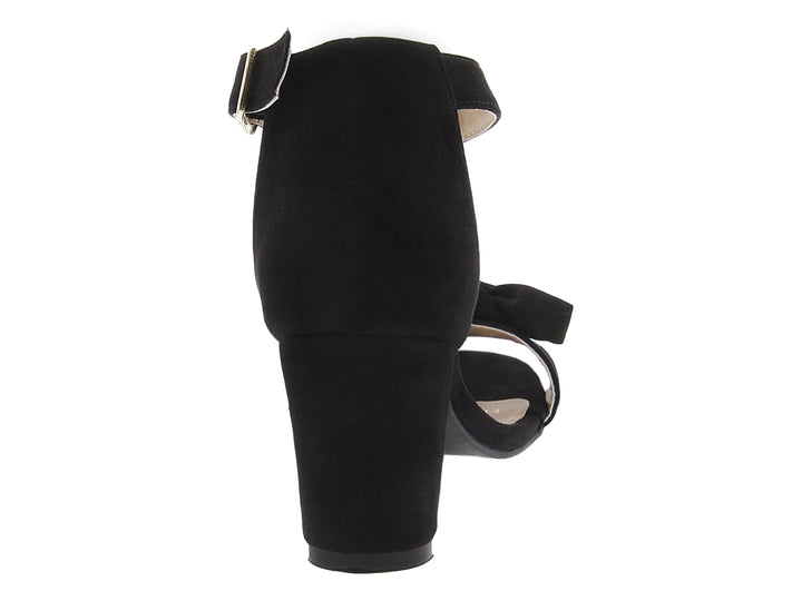 Sandalias negras de tacón grueso con moño frontal y correa al tobillo con hebilla dorada.