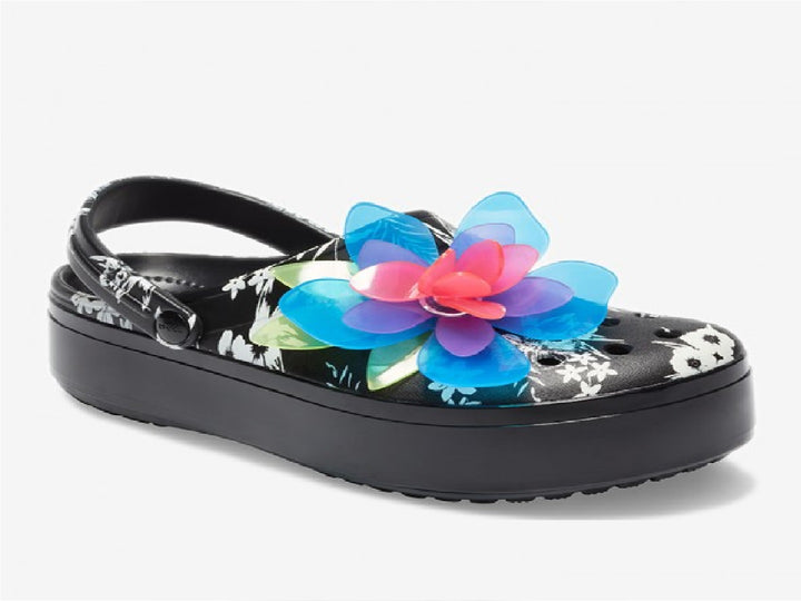 Zuecos Crocs negros con plataforma, estampado floral y una gran flor decorativa en colores neón.