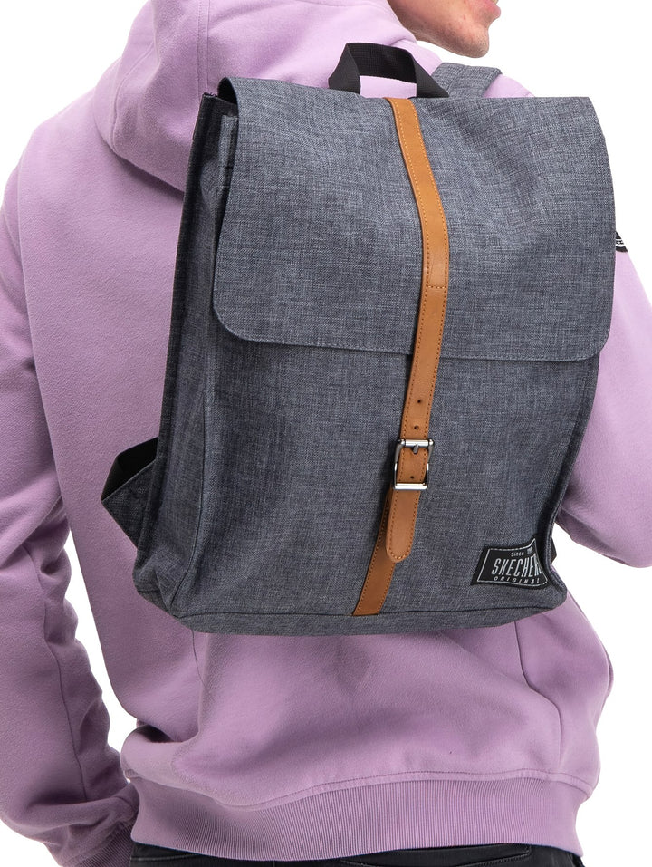 Mochila Skechers color gris con correa central marrón y hebilla metálica.
