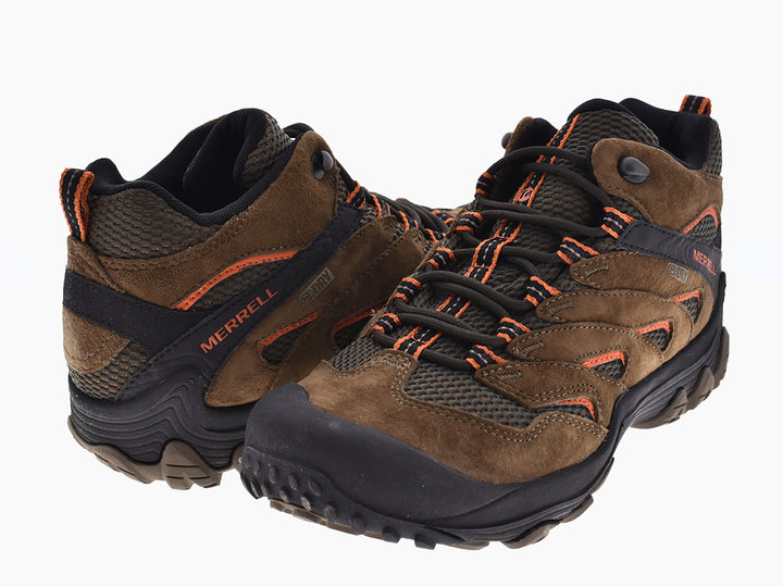Zapatos de senderismo Merrell color café y negro con detalles naranjas y suela resistente.