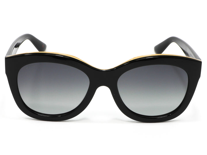Lentes de sol Cloe para mujer en color negro con detalle dorado superior y micas degradadas.