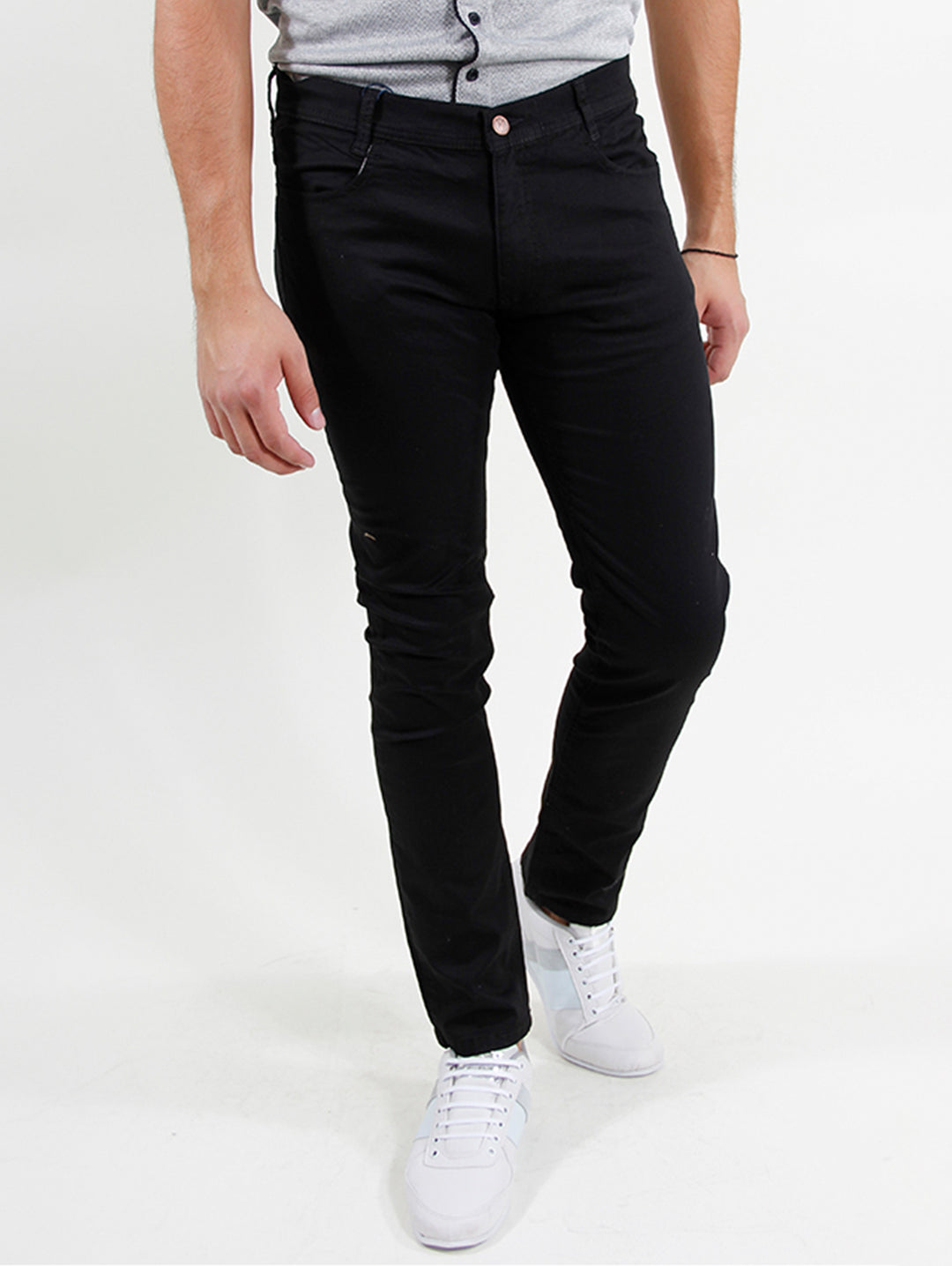 Hombre vistiendo pantalón negro ajustado con tenis blancos.