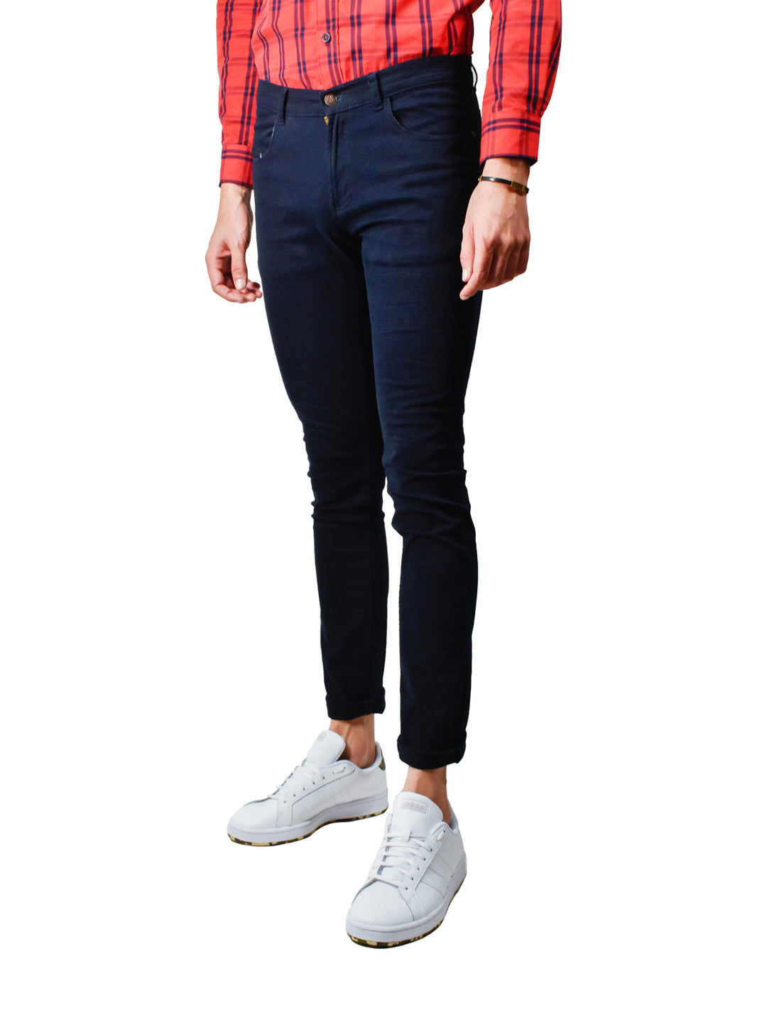 Hombre vistiendo pantalón ajustado color marino con tenis blancos y camisa a cuadros roja.