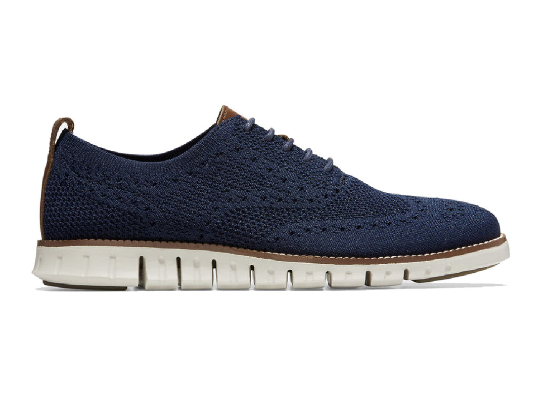 Par de zapatos casuales Cole Haan en color azul marino con suela blanca y detalles en café.