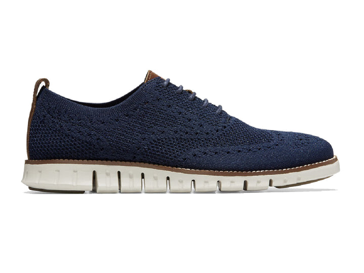 Par de zapatos casuales Cole Haan en color azul marino con suela blanca y detalles en café.