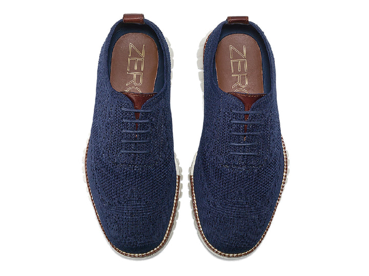 Par de zapatos casuales Cole Haan en color azul marino con suela blanca y detalles en café.
