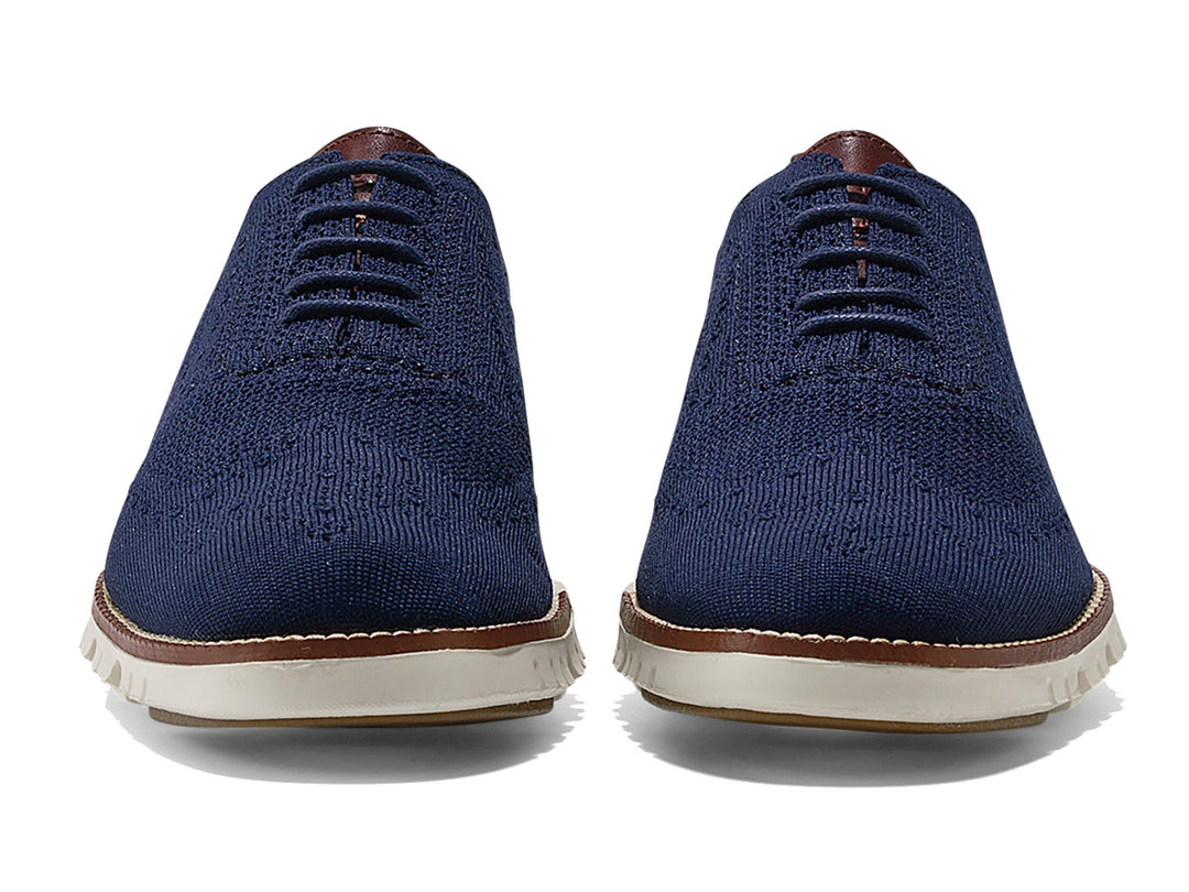 Par de zapatos casuales Cole Haan en color azul marino con suela blanca y detalles en café.