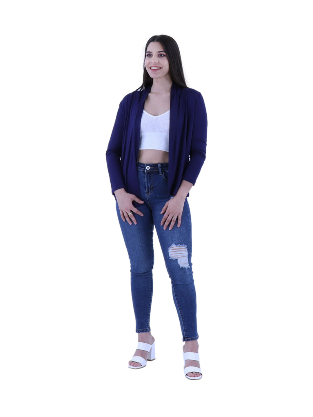 Mujer vistiendo un cardigan abierto de color azul oscuro sobre un top blanco y jeans azules.