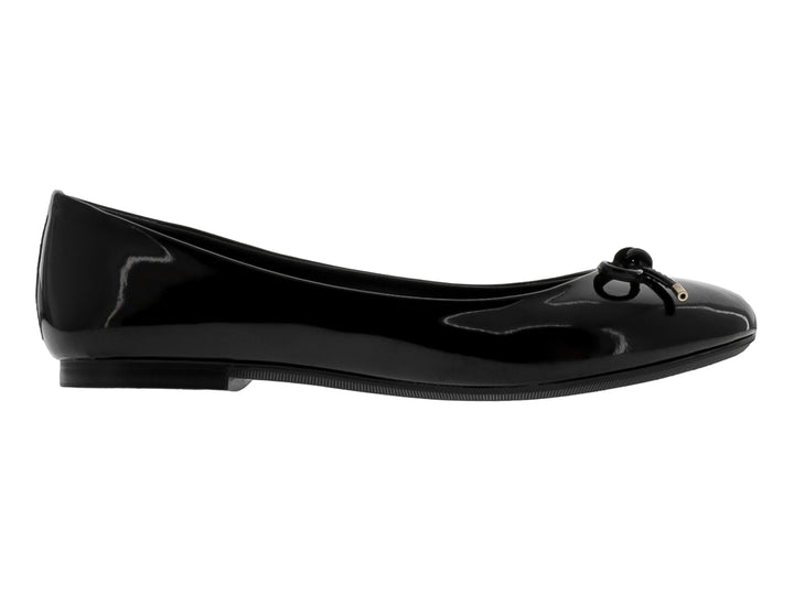 Zapato plano tipo balerina en charol negro brillante con un moño decorativo y detalles dorados.