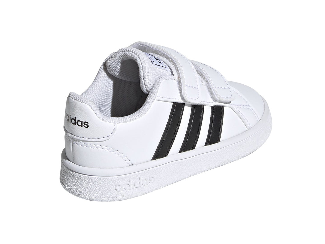 Tenis Adidas Grand Court blancos con tres franjas negras y cierre de velcro.