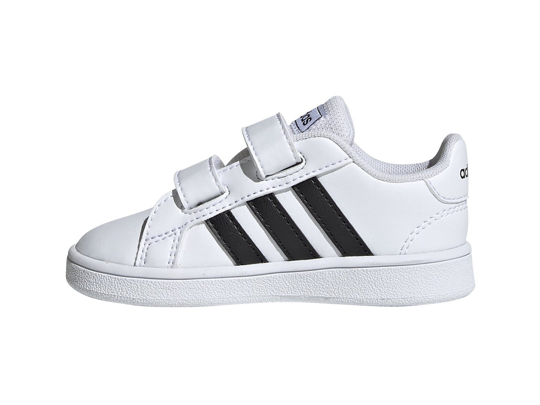 Tenis Adidas Grand Court blancos con tres franjas negras y cierre de velcro.