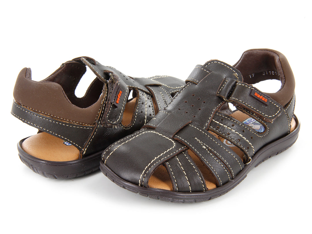 Sandalias color café para niño con diseño de correas y costuras blancas.